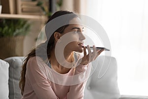 Woman holding smartphone using virtual assistant or talk on speakerphone