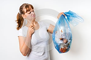 Woman holding a smelly garbage bag
