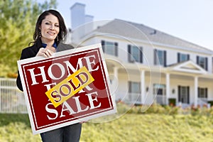 Woman Holding Sold Home Sale Sign in Front of House