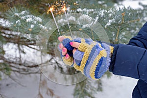 Woman holding sparklers in winter