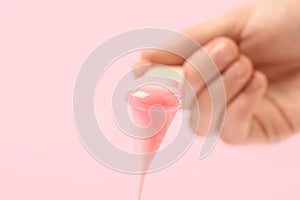 Woman holding spatula with hot depilatory wax on light background, closeup. Space for text