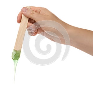 Woman holding spatula with hot depilatory wax on white background, closeup