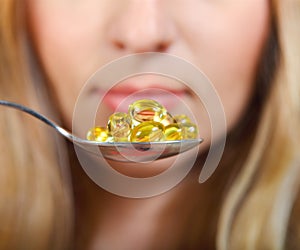 Woman holding a spoon full of pills