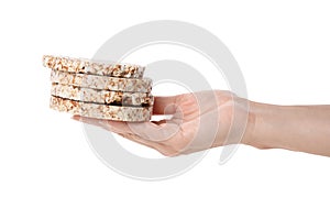 Woman holding stack of crunchy crispbreads on white background, closeup