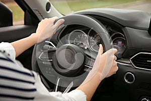 Woman holding steering wheel in car, closeup.