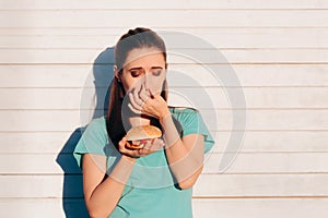 Woman Holding a Stinky and Disgusting Burger