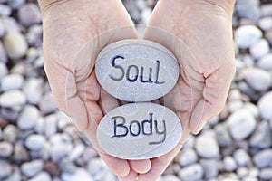 Woman holding stone with the words Soul and Body in her palms
