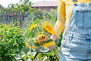 Woman holding sunflowers in summer garden