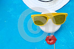 Woman holding sunglasses on bright background, cosmetic summer concept