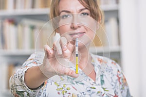 Woman is holding syringe with insulin or heparin