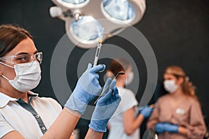 Woman holding syringe. In the stomatological cabinet