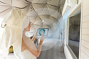 woman holding a tablet computer with system clever house on a screen on the background of the house