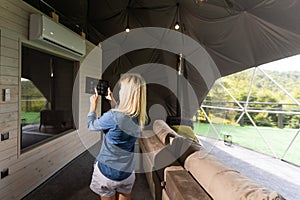 woman holding a tablet computer with system clever house on a screen on the background of the house