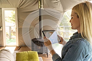 woman holding a tablet computer with system clever house on a screen on the background of the house