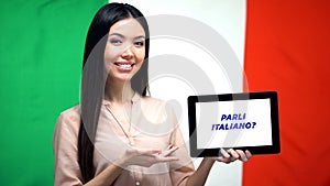 Woman holding tablet with do you speak italian phrase, app for learning language