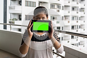 Woman holding tablet in her handswith blank green screen photo
