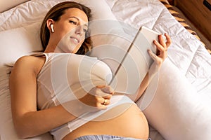 Woman holding tablet. Mobile pregnancy online maternity application. Pregnant mother using digital tablet. Pregnancy
