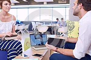 Woman holding tablet while paying attention to male business partner