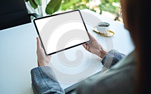 A woman holding tablet pc with blank white desktop screen in the office