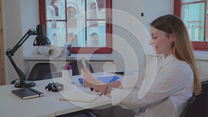 Woman holding tablet smiling and greeting client.