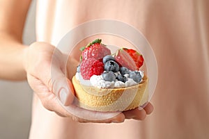 Woman holding tart with different berries, . Delicious pastries