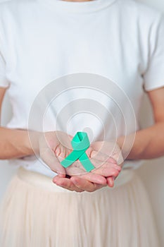 woman holding Teal Ribbon for January Cervical Cancer Awareness month. Uterus and Ovaries, Cervix, Endometriosis, Hysterectomy,