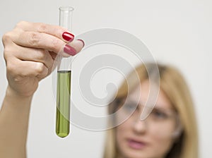 Woman holding a test tube with dirty water