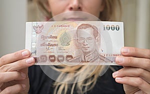 Woman holding 1000 Thai Baht note withdrawn from ATM photo