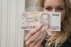 Woman holding 1000 Thai Baht note withdrawn from ATM photo