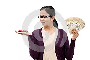 Woman holding a toy car and Indian rupee notes