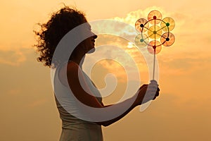 Woman holding toy whirligig at sunset
