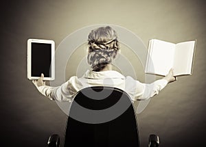 Woman holding traditional book and e-book reader