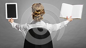 Woman holding traditional book and e-book reader