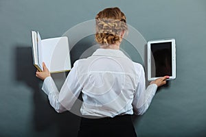 Woman holding traditional book and e-book reader