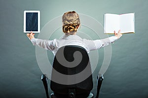 Woman holding traditional book and e-book reader