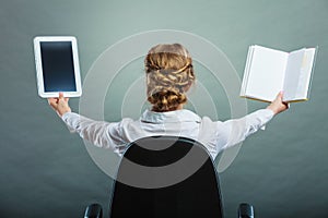 Woman holding traditional book and e-book reader