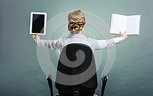 Woman holding traditional book and e-book reader