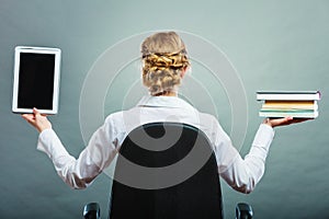 Woman holding traditional book and e-book reader