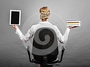 Woman holding traditional book and e-book reader