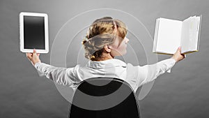 Woman holding traditional book and e-book reader