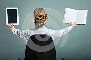 Woman holding traditional book and e-book reader