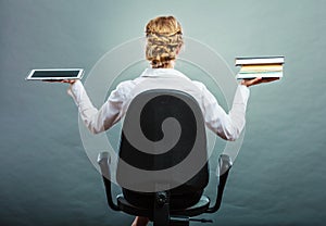 Woman holding traditional book and e-book reader