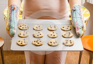 Woman holding a tray with baked cookies with kitch