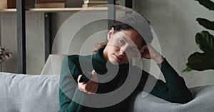 Woman holding TV remote control switch channels feels bored