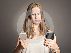 Woman holding two cellulars photo