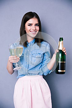 Woman holding two glass and bottle of champagne