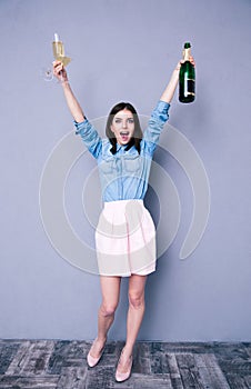Woman holding two glass and bottle of champagne