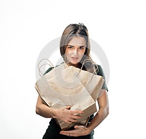 Woman is holding two grocery shopping bags on white background. Paper bag near face. Isolated background.