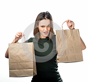 Woman is holding two grocery shopping bags on white background. Paper bags in hands. Isolated background.