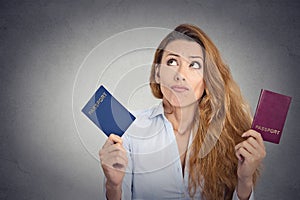 Woman holding two passports confused face expression